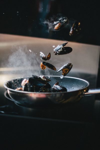 mussels being cooked in a pan